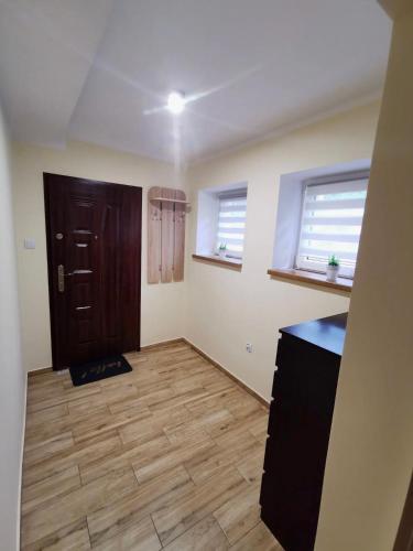 an empty room with a door and a wooden floor at Apartament położony u podnóża Gór Bardzkich in Bardo