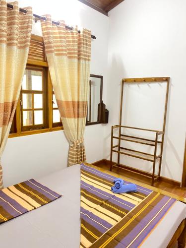 a room with curtains and a table with a mirror at Happy Feet Diyaluma in Koslanda