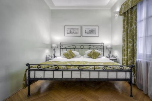 a bedroom with a black bed with two pillows at Black Star Suites in Prague
