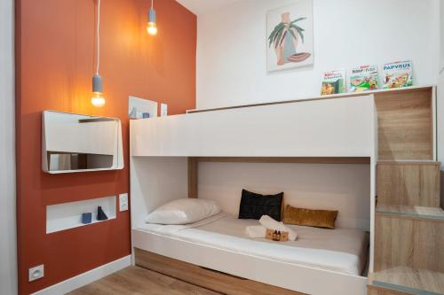 Ce lit superposé se trouve dans une petite chambre aux murs orange. dans l'établissement Loft L'Escale - 3 étoiles - Welkeys, à La Ciotat