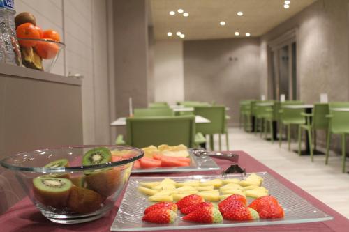 una mesa con dos platos de fruta y un tazón de fresas en Hotel Jardí Apartaments, en Mollerusa