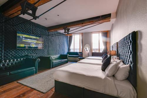 a bedroom with a bed and a couch and a television at Boutique 56 in Liverpool