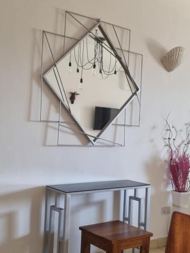 a mirror hanging on a wall next to a table at Lamera in Mombasa