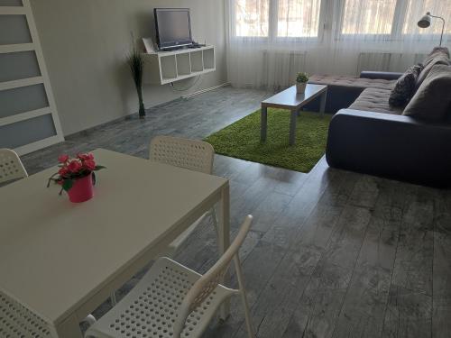 a living room with a couch and a table and chairs at Palota Apartman in Gödöllő