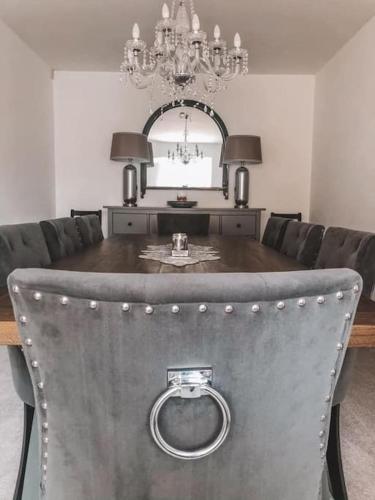 a dining room with a table and a chandelier at New 4 Bedroom Countryside Home in Rudloe