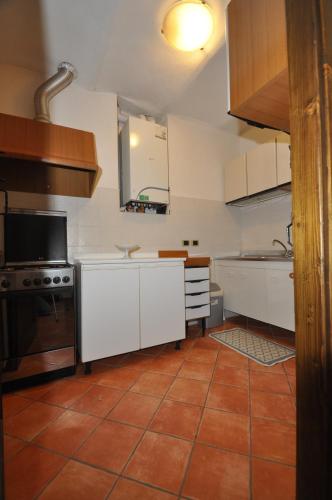 a kitchen with white cabinets and a tile floor at B&B Casa Camilla - Affitti Brevi Italia in Niella Tanaro