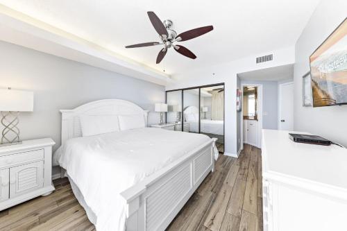 a white bedroom with a bed and a ceiling fan at Summer House 1105A in Orange Beach