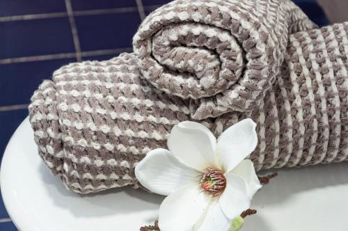 een gehaakte handdoek met een witte bloem op een wastafel bij Apartamento con terraza y vistas al canal by InsideHome in Empuriabrava