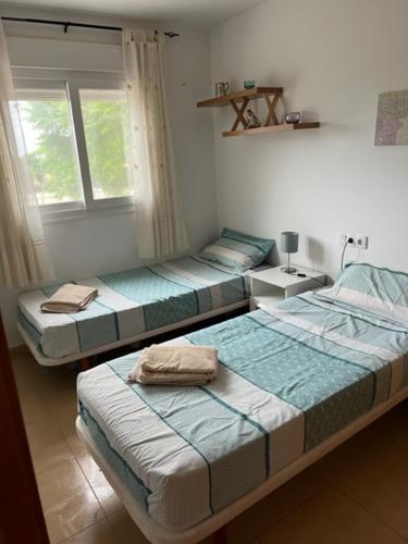3 Betten in einem Zimmer mit Fenster in der Unterkunft 2 Bedroom Apartment Condado de Alhama in Alhama de Murcia