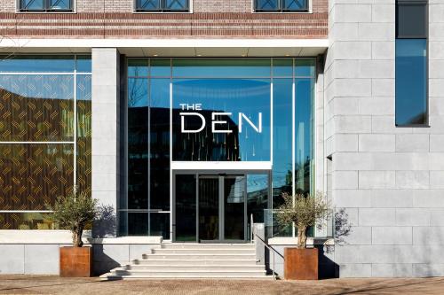 a glass building with the dean sign on it at The Den, 's-Hertogenbosch, a Tribute Portfolio Hotel in Den Bosch
