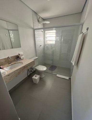 a bathroom with a sink and a toilet and a shower at Hotel Casa Paradiso Guarujá in Guarujá