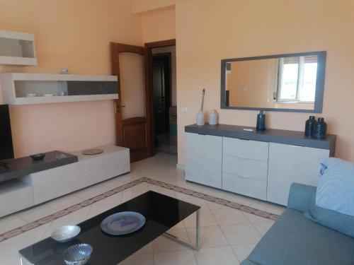 a living room with a kitchen and a mirror at La Playa di Ponente in Cagliari