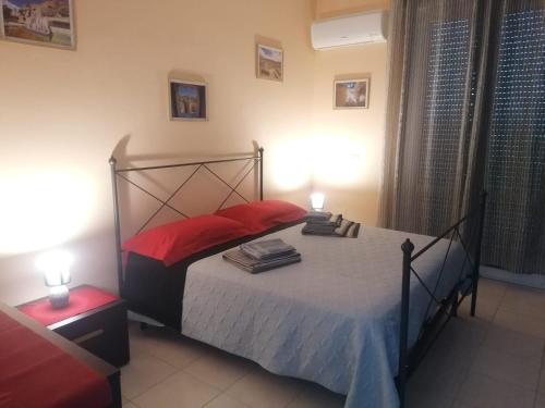 a bedroom with a bed with red pillows and two lamps at La Playa di Ponente in Cagliari