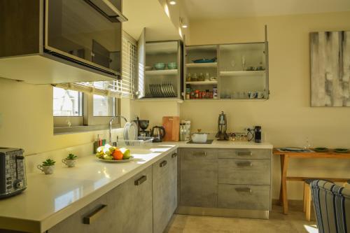 a kitchen with stainless steel cabinets and a bowl of fruit on the counter at Filia Luxury Apartments in Chania Town