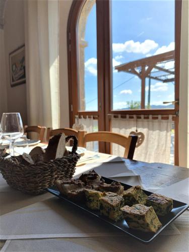 a plate of food on a table with a basket of food at Agriturismo Il Filare in Neviano degli Arduini