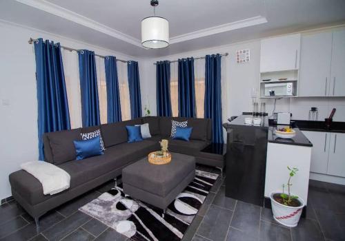 uma sala de estar com um sofá e uma cozinha em Banjii's Cottage em Lusaka