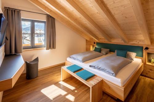 1 dormitorio en una cabaña de madera con 1 cama en Riedbergerhorn - Gasthof & Ferienwohnungen, en Bolsterlang