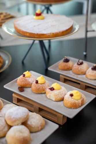 a bunch of donuts on trays with a cake at Clipper in Pesaro