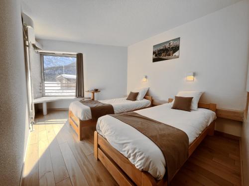 Dos camas en una habitación con ventana. en La Bessannaise, en Bessans