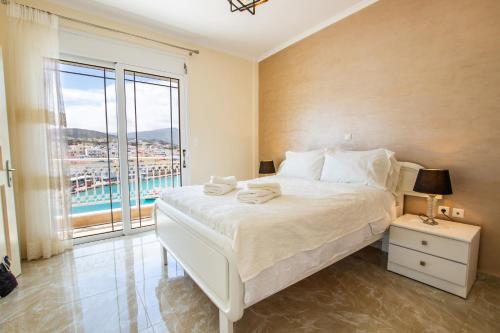 a bedroom with a large bed and a large window at Casa Jokaste in Karpathos