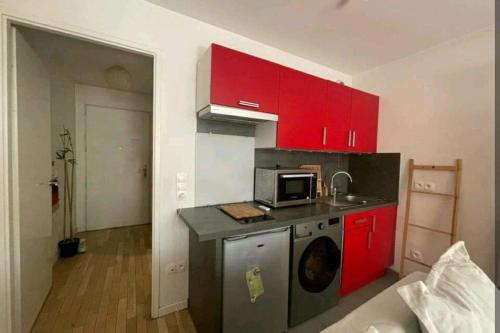 uma cozinha com armários vermelhos e uma máquina de lavar roupa em Studio 30m2 near Paris em Boulogne-Billancourt