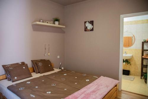 a bedroom with a bed and a bathroom at Angyalszív Apartman in Zalakaros