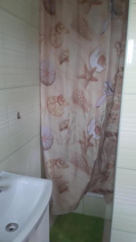 a bathroom with a shower curtain with fish on it at Świętokrzyski Zakątek Porąbki 111a 26-004 Bieliny in Bieliny