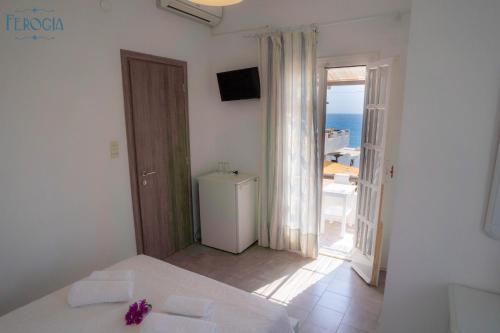 een witte kamer met een koelkast en een balkon bij Ferogia in Skiros