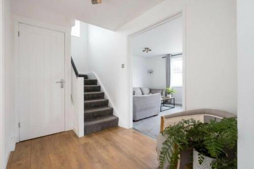 a white hallway with a staircase in a house at Cosy 4 Bedroom Town House Ample Parking & Netflix in Leominster