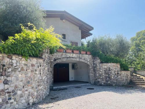 uma parede de pedra com uma garagem em frente a uma casa em Il borgo fra i laghi em Monzambano