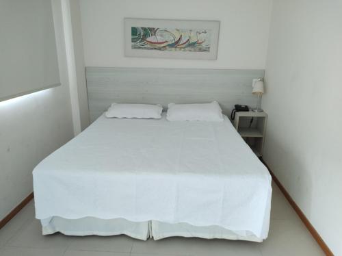 białe łóżko z 2 poduszkami w sypialni w obiekcie Porto Marina Mont Blanc Resort II w mieście Mangaratiba