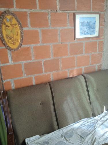 a brick wall with a couch and a clock on a wall at Wanda aloja in Wanda