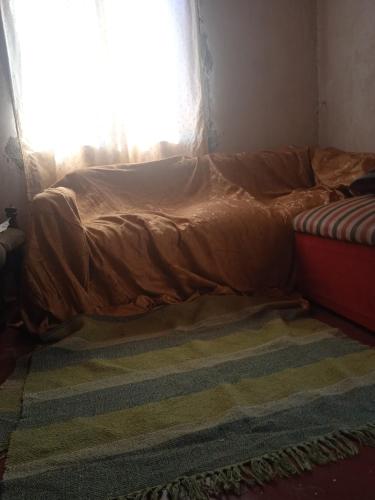 an unmade bed in a room with a window at Wanda aloja in Wanda
