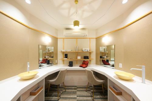 a dressing room with two sinks and mirrors at Meitei no Yado Hotel Koshien in Fuefuki