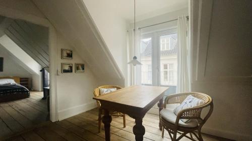 コペンハーゲンにあるApartmentInCopenhagen Apartment 298のダイニングルーム(木製テーブル、椅子付)