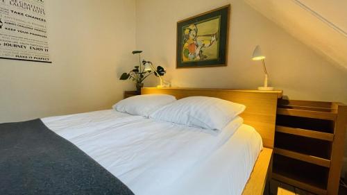 a bed with white sheets and a wooden head board at ApartmentInCopenhagen Apartment 298 in Copenhagen