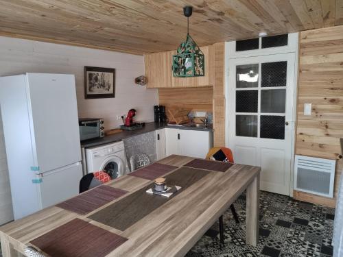 une cuisine avec une table en bois et un réfrigérateur dans l'établissement Isabelle, à Meyrueis