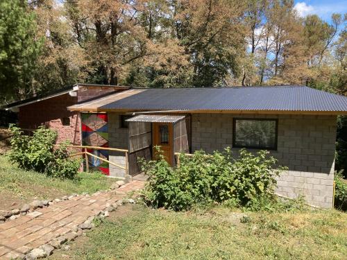 una casa de ladrillo con un techo negro en un campo en Casa Trina en San Martín de los Andes