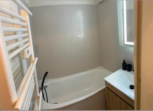 une salle de bain blanche avec une baignoire et un lavabo dans l'établissement Studio 4 personnes - accès direct remontées mécaniques, aux Contamines-Montjoie