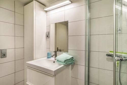 a white bathroom with a sink and a shower at Ferienwohnung Dusamos in Bühlertal
