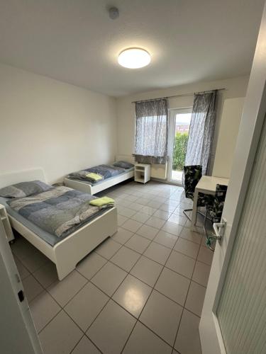 a bedroom with two beds and a desk in it at Gästezimmer - Elbert in Hösbach