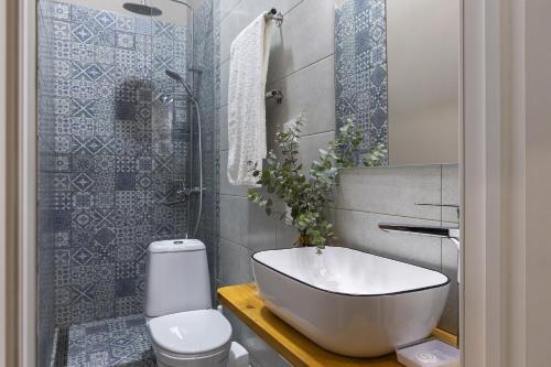 y baño con bañera, aseo y lavamanos. en Апартаменты Comfort Life 91 en Almaty