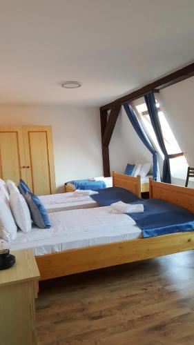 a bedroom with two beds with blue pillows at Visnyó Vendégház in Nagyvisnyó