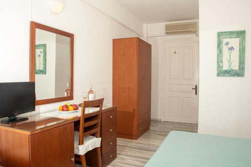 a bedroom with a desk with a mirror and a television at 7 Islands in Spetses