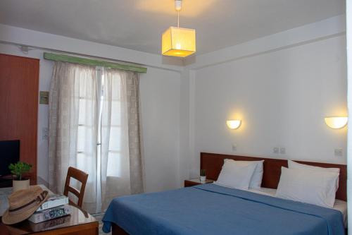 a bedroom with a blue bed and a window at 7 Islands in Spetses