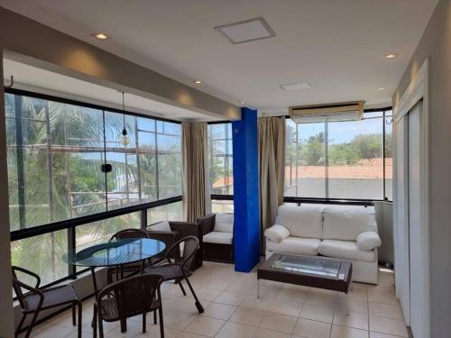 a living room with a couch and a table and chairs at Apartamento pé na areia in São Luís