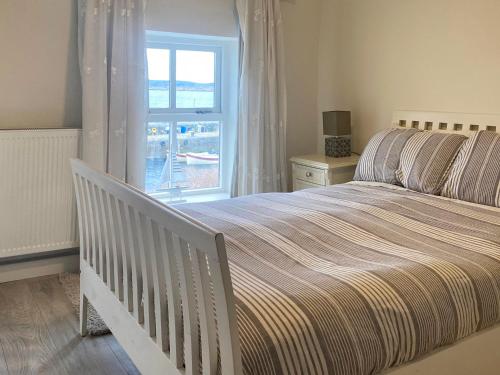 a bedroom with a large bed and a window at Cottage 170 - Roundstone in Roundstone