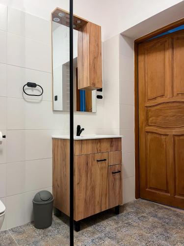 a bathroom with a sink and a wooden door at Dwór Jeziory Wielkie in Jeziory Wielkie