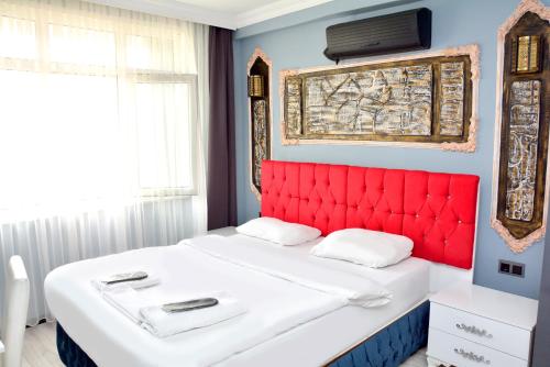 łóżko z czerwonym zagłówkiem w pokoju w obiekcie palmiye suıt otel w Stambule