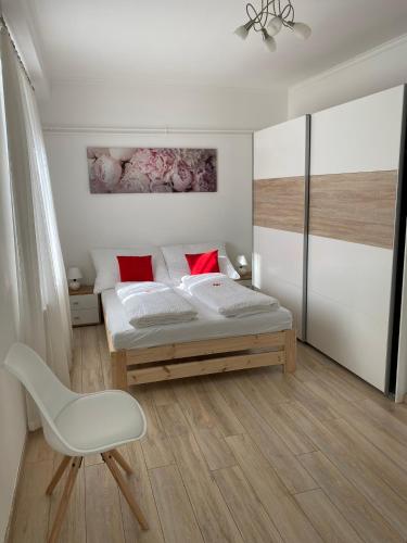 a bedroom with a bed and a chair in it at Peter Apartman in Szeged